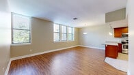 Located at 301 Warren Ave in Baltimore's South Baltimore neighborhood, this single-floor residence offers a well-designed layout with a cohesive, neutral color palette and quality finishes throughout. The open living and dining area is anchored by rich hardwood-style flooring and bathed in natural light from a bank of windows fitted with blinds, creating a bright and welcoming atmosphere. A pendant light fixture accentuates the dining zone, which flows seamlessly into the kitchen. The kitchen is a functional centerpiece, featuring warm cherry wood cabinetry, granite countertops, a central island with additional counter space, and a full suite of stainless steel appliances including a range, microwave, dishwasher, and refrigerator with an ice maker. Light tile flooring grounds the kitchen space. The bedroom offers plush carpeting and generous wall space, providing a calm and comfortable retreat. Two full bathrooms are finished with granite-topped vanities, large mirrors, chrome fixtures, and tiled tub-shower combinations, maintaining a clean and consistent style. The overall design balances practicality with comfortable living in a straightforward, move-in-ready layout.