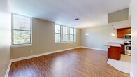Located at 301 Warren Ave in Baltimore's South Baltimore neighborhood, this single-floor residence offers a well-designed layout with a cohesive, neutral color palette and quality finishes throughout. The open living and dining area is anchored by rich hardwood-style flooring and bathed in natural light from a bank of windows fitted with blinds, creating a bright and welcoming atmosphere. A pendant light fixture accentuates the dining zone, which flows seamlessly into the kitchen. The kitchen is a functional centerpiece, featuring warm cherry wood cabinetry, granite countertops, a central island with additional counter space, and a full suite of stainless steel appliances including a range, microwave, dishwasher, and refrigerator with an ice maker. Light tile flooring grounds the kitchen space. The bedroom offers plush carpeting and generous wall space, providing a calm and comfortable retreat. Two full bathrooms are finished with granite-topped vanities, large mirrors, chrome fixtures, and tiled tub-shower combinations, maintaining a clean and consistent style. The overall design balances practicality with comfortable living in a straightforward, move-in-ready layout.