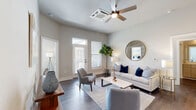 Located at 105 Ivy Green Way in Charleston, SC, this well-designed 2-bedroom, 2-bathroom residence offers a thoughtful single-floor layout with modern finishes throughout. Dark hardwood-style flooring flows continuously across the open-concept living, dining, and kitchen areas, creating a cohesive and polished aesthetic.

The kitchen is a standout feature, showcasing flat-front cabinetry in a warm wood tone complemented by crisp white upper cabinets and a large central island with a white quartz countertop, undermount sink, and bar seating. Stainless steel appliances, including a French door refrigerator and built-in microwave, complete the contemporary look.

The living room is bright and welcoming, benefiting from multiple windows and a glass door that invite natural light and provide outdoor access. A ceiling fan adds comfort to the space.

The spacious primary bedroom offers a wall-mounted mini-split system and direct access to a well-appointed closet with wire shelving. The primary bathroom features a sleek vanity with a white countertop and a walk-in shower. The second bedroom is equally comfortable, with its own adjacent bathroom featuring a matching modern vanity. Both bathrooms maintain the home's clean, neutral palette with wood-look flooring and ample storage.