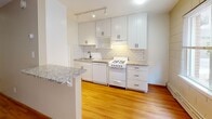 Located at 3618 Colfax Ave S in the vibrant Kingfield neighborhood of Minneapolis, MN, this single-floor unit offers a well-appointed layout with a blend of classic architectural character and modern updates. The living area features warm hardwood flooring and distinctive painted concrete block walls that lend an industrial charm, complemented by a large window that invites natural light and offers views of the surrounding neighborhood. A baseboard heating system ensures year-round comfort.

The kitchen has been thoughtfully updated with crisp white shaker cabinetry, granite countertops, a subway tile backsplash, and track lighting overhead. A peninsula with a granite overhang provides additional prep space and a casual dining option. Appliances include a gas range and dishwasher, making the kitchen both functional and stylish.

The bathroom showcases classic design details including penny tile flooring, subway tile surrounding the shower/tub combination, a pedestal sink, and a mirrored medicine cabinet with built-in storage. A natural wood door adds a warm, traditional touch to the space.

Throughout the unit, the combination of hardwood floors, updated finishes, and enduring architectural details creates a cohesive and comfortable living environment in one of Minneapolis's well-established residential neighborhoods.