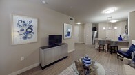 This single-story residence offers a thoughtfully designed layout that balances functionality and comfort throughout. The open-concept living area is anchored by warm wood-look flooring that extends seamlessly through the main spaces, creating a cohesive and inviting atmosphere. The living room provides ample space for relaxation and entertaining, with neutral-toned walls that complement the natural light filtering in through large windows dressed with bold navy curtains. An elegant arched entryway connects the living area to the bedroom wing, adding a refined architectural touch.

The kitchen is a standout feature, showcasing rich dark cabinetry that reaches toward the ceiling, granite countertops, a tile backsplash, and a full suite of stainless steel appliances. A breakfast bar offers additional seating and serves as a natural divider between the kitchen and living areas.

The bedrooms are carpeted for comfort and each feature ceiling fans, generous closet space with built-in shelving, and windows that allow for natural light. The primary bedroom includes an organized walk-in style closet, providing practical storage solutions.

The bathroom is clean and functional, featuring a full soaking tub with shower, dark vanity cabinetry with granite countertops, and wood-look tile flooring that ties the space together. Throughout, the neutral color palette and consistent finishes create a calm, polished ambiance.