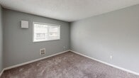 Located at 2106 S 272nd St in Kent, WA, this one-bedroom, one-bathroom unit offers a practical and efficiently designed single-floor layout. The interior features soft carpet throughout the main living and bedroom areas, complemented by neutral gray walls and textured ceilings that create a clean, understated aesthetic.

The living room is open and airy, with a wall-mounted mini-split unit for climate control and direct access to a private balcony through a sliding glass door, allowing for natural light and outdoor views. The kitchen is adjacent to the main hallway and features white cabinetry with wood-trim accents, dark laminate countertops, hardwood-style flooring, a coil-top electric range, a dishwasher, and a ventilation hood.

The bedroom is a generously sized, carpeted retreat with a large window that brings in ample natural light and offers views of the surrounding neighborhood. The room includes convenient access to closet storage. Three closets throughout the unit provide notable storage capacity for a space of this size.

The bathroom is clean and straightforward, featuring a full tub and shower combination with white surrounds, wood-style flooring, and a granite-style countertop. The unit includes an electrical panel located in the entry hallway, adding functional accessibility. Overall, the space delivers a practical, move-in-ready environment suited for comfortable everyday living.