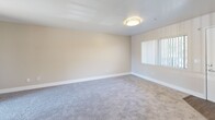 Located at 3939 Cranford Ave in Riverside, CA, this single-floor, one-bedroom, one-bathroom unit offers a practical and well-organized layout across a compact, efficient footprint. The living room is bright and welcoming, featuring neutral beige walls, soft carpeting, and a sliding glass door that opens to a private patio, filling the space with natural light and outdoor views. A front entry door and window further contribute to the open, airy feel of the room.

The kitchen is thoughtfully appointed with white cabinetry, speckled laminate countertops, a double-basin stainless steel sink, and a white dishwasher. A window above the sink allows natural light to brighten the workspace.

The bedroom offers a comfortable and quiet retreat, with plush carpeting, neutral walls, vertical blinds on the window, and a set of sliding closet doors providing generous storage. The room receives natural light, contributing to a calm and restful atmosphere.

The bathroom features wood-look vinyl flooring and a clean, white tiled tub-shower combo with chrome fixtures and a curtain rod, complemented by neutral-toned walls. The overall palette throughout the unit is consistent—warm beige tones, white trim, and soft carpeting—creating a cohesive and move-in-ready living environment.