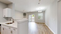 Located at 1319 Fonthill Ct in Langhorne, PA, this one-bedroom, one-bathroom unit offers a thoughtfully designed single-level layout with modern finishes throughout. Light wood-tone flooring runs consistently across all rooms, complementing the soft neutral gray walls and white trim to create a clean, cohesive aesthetic.

The living room serves as the centerpiece of the unit, featuring a fireplace with a classic white mantle, a built-in arched display niche, a chandelier, and direct access to a private balcony through sliding glass doors. A large window alongside the balcony entrance fills the space with natural light and outdoor views. The open-concept design connects the living area to the kitchen, which is separated by a peninsula counter finished with marble-look quartz. White shaker cabinetry, stainless steel appliances, and a dishwasher complete the kitchen.

The generously sized primary bedroom offers a quiet, neutral environment with ample wall space and a paneled white door with brass hardware. The full bathroom features a white vanity with multiple drawers, a large mirror with overhead lighting, wood-look flooring, and accessibility-conscious grab bars. A hallway with a louvered utility closet connects the main living areas, adding practical storage to the well-organized layout.
