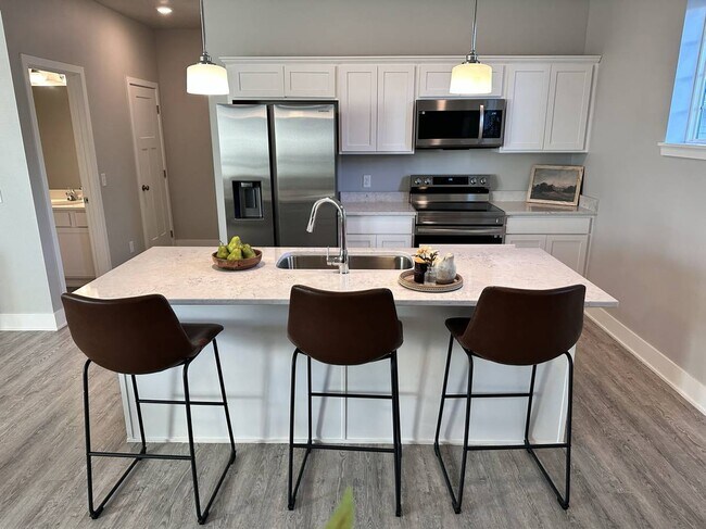 Open kitchen with an island and top-class appliances - 214 NW Common Pl