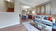 Located at 44800 Van Dyke Ave in Utica, Michigan, this two-story residence offers a thoughtfully designed layout with a warm, contemporary aesthetic throughout. The open-concept main level seamlessly connects the living and dining areas, both finished with rich wood-look flooring. The living room features crown molding, angled ceiling details, and abundant natural light from large windows dressed with elegant curtains. The adjacent dining area is anchored by a pendant light fixture and offers generous space for entertaining.

The kitchen is outfitted with dark espresso cabinetry, granite countertops, a mosaic tile backsplash, and a full suite of black appliances, including a gas range, built-in microwave, and refrigerator. A half bath on the main level features neutral tones and decorative wall art.

Upstairs, the primary bedroom is bright and spacious, with multiple windows, plush carpeting, and a calm, neutral color palette. A secondary bedroom makes a bold design statement with a deep terra cotta accent wall, carpet flooring, and ample natural light. A full bathroom serves the upper level, complete with a vanity featuring dark wood cabinetry, a framed mirror, tiled tub-shower, and tile flooring. The overall ambiance is modern and inviting throughout.