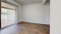 Located at 2004 Stoneycreek Dr in High Point, NC, this single-floor unit offers five bedrooms and two full bathrooms within a well-utilized floor plan. The layout is connected by two hallways, providing clear circulation between the living spaces, bedrooms, and shared areas.

The living room features rich, dark hardwood-style flooring and a textured ceiling, with vertical blinds allowing for natural light control. This flooring continues into the kitchen, which is equipped with bold slate-gray cabinetry, white appliances including a range, dishwasher, and refrigerator, and a double sink. A built-in closet with shelving is conveniently positioned adjacent to the kitchen area.

The five bedrooms are finished with neutral carpet, offering a comfortable and quiet atmosphere. The spacious primary bedroom includes a walk-in closet with built-in shelving. Additional bedrooms are well-proportioned and share access to the hallways.

Both bathrooms feature wood-style flooring, white tub-shower combinations, and coordinating gray vanity cabinetry, maintaining a consistent design aesthetic throughout. The textured ceilings appear throughout the unit, adding a consistent architectural finish to each room.