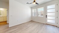 Located at 2301 Westside Blvd SE in Rio Rancho, New Mexico, this single-story, 2-bedroom, 3-bathroom home offers a clean, modern design with light-toned luxury vinyl plank flooring throughout. The open-concept living area flows seamlessly into the kitchen, where white shaker cabinetry extends to the ceiling for generous storage, complemented by stainless steel appliances, a tile backsplash, quartz countertops, and a peninsula with a built-in sink. Ceiling fans are present in the living area and both bedrooms, enhancing comfort year-round. The entry features a built-in mudroom-style nook with hooks and a bench, adding practical functionality. The primary bedroom is a comfortable retreat with natural light and direct access to an en suite bathroom, which includes a walk-in glass-enclosed shower, single vanity, and an adjoining walk-in closet with wire shelving. The second bedroom is bright and airy, with windows overlooking the neighborhood. Three full bathrooms provide ample convenience. The attached garage offers direct interior access and solid storage potential. Outside, a private enclosed yard features low-maintenance gravel xeriscaping, block wall fencing, and a wooden gate — well-suited for the high desert climate of New Mexico.