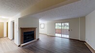 Located at 171 Applegrove St NE in North Canton, Ohio, this one-bedroom, one-bathroom home offers a well-organized, single-floor layout with a variety of functional spaces including a living room, dining room, kitchen, hallway, entrance, utility room, and a private patio. The open living and dining area is a standout feature, highlighted by rich hardwood-style flooring, a textured ceiling, and a wood-trimmed fireplace that serves as a natural focal point. Sliding glass doors lead directly to the patio, allowing natural light to fill the space and providing easy access to the outdoors. The kitchen is equipped with warm oak cabinetry, a double sink, and black appliances including a range and refrigerator, all set atop matching hardwood-style flooring. The bedroom is a comfortable retreat featuring plush carpeting, a natural window view, and access to an exceptionally spacious walk-in closet with dual clothing rods and shelving. Three additional closets throughout the home provide ample storage. The full bathroom includes an oak vanity with a wide mirror, a soaking tub and shower combination, and light hardwood-style flooring. A dedicated utility room and hallway complete this practical and inviting floor plan.