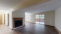 Located at 171 Applegrove St NE in North Canton, Ohio, this one-bedroom, one-bathroom home offers a well-organized, single-floor layout with a variety of functional spaces including a living room, dining room, kitchen, hallway, entrance, utility room, and a private patio. The open living and dining area is a standout feature, highlighted by rich hardwood-style flooring, a textured ceiling, and a wood-trimmed fireplace that serves as a natural focal point. Sliding glass doors lead directly to the patio, allowing natural light to fill the space and providing easy access to the outdoors. The kitchen is equipped with warm oak cabinetry, a double sink, and black appliances including a range and refrigerator, all set atop matching hardwood-style flooring. The bedroom is a comfortable retreat featuring plush carpeting, a natural window view, and access to an exceptionally spacious walk-in closet with dual clothing rods and shelving. Three additional closets throughout the home provide ample storage. The full bathroom includes an oak vanity with a wide mirror, a soaking tub and shower combination, and light hardwood-style flooring. A dedicated utility room and hallway complete this practical and inviting floor plan.