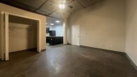 This 410 square foot space showcases an industrial-chic aesthetic, blending functionality with modern design elements. The single-floor layout maximizes efficiency, featuring an open concept that seamlessly integrates living and dining areas. Polished concrete floors run throughout, adding an urban edge while providing durability.

The kitchen, visible from the main living space, boasts sleek black cabinetry and white subway tile backsplash, creating a striking contrast. A compact yet functional design includes essential appliances and ample counter space.

High ceilings with exposed ductwork and pipes contribute to the loft-like atmosphere, while suspended light fixtures provide targeted illumination. A ceiling fan aids in air circulation, enhancing comfort.

The bathroom continues the modern theme with a vessel sink atop a dark vanity, complemented by a blue glass bowl. A white shower/tub combination and toilet complete the essential fixtures.

Storage solutions include a closet with bi-fold doors, cleverly integrated into the main living area. Windows, though limited, allow natural light to filter in, softening the industrial elements.

This space, while compact, offers a contemporary urban living experience, ideal for those seeking a low-maintenance, stylish residence in the heart of St. Joseph, Missouri.