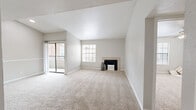 This well-organized single-floor residence offers 2 bedrooms and 2 bathrooms with a functional and comfortable layout. The spacious living room is a standout feature, boasting vaulted ceilings, soft wall-to-wall carpeting, and a tile-surround fireplace that serves as an attractive focal point. Natural light fills the room through multiple windows, while a sliding glass door opens to a private balcony with exterior views. The galley-style kitchen is efficiently designed with white cabinetry, dark granite-style countertops, hardwood flooring, and black appliances including a range and dishwasher, complemented by a window that brings in additional natural light. Both bedrooms are carpeted and equipped with ceiling fans with integrated lighting. The primary bedroom is generously sized and features a walk-in closet outfitted with wire shelving and hanging rods on both sides, providing ample storage. The second bedroom also includes a ceiling fan and closet access. The two bathrooms include tub-shower combinations. An entrance, hallway, and two closets complete the floor plan, ensuring practical storage and circulation throughout the home.