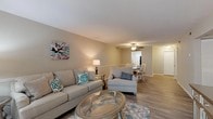 Located at 1503 E Park Ave in Valdosta, Georgia, this single-floor residence offers a well-designed layout that balances comfort and functionality. The open-concept living and dining area forms the heart of the home, with hardwood-style flooring running throughout and neutral warm-toned walls that create a welcoming atmosphere. Large sliding glass doors fitted with vertical blinds allow an abundance of natural light to fill the living space while providing outdoor views of surrounding greenery. A ceiling fan overhead adds to the room's practicality and charm.

The kitchen features granite-style countertops, gray shaker cabinetry with brushed nickel hardware, a stainless steel sink, and black appliances — delivering a clean, modern aesthetic. The dining area flows seamlessly from the living room, making the space ideal for entertaining.

The bedrooms are generously proportioned, each with hardwood-style flooring, neutral gray walls, and windows that invite natural light. The primary bedroom includes access to a private hallway and closet space. Two full bathrooms serve the home, each equipped with a tub-shower combination. The overall design is cohesive, with a consistent neutral palette and modern finishes that give the entire residence a fresh, move-in-ready appeal.