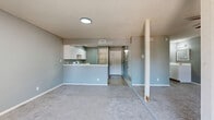 Located at 9110 Broadway in San Antonio, Texas, this efficiently designed unit offers a functional and comfortable single-floor layout. The combined kitchen and living area forms the heart of the space, featuring soft gray walls, plush carpeting, and a textured ceiling throughout. A ceiling fan with a light fixture adds both style and practicality to the living area, which is bathed in natural light from windows and a sliding glass door that opens to a private balcony — ideal for enjoying outdoor views. A structural column adds an architectural accent to the open living space. The kitchen is thoughtfully laid out with crisp white cabinetry, light-toned countertops, a stainless steel sink, and white appliances including an electric range. The peninsula-style counter seamlessly separates the kitchen from the living area while maintaining an open feel. Wood-look flooring grounds the kitchen, complementing the neutral palette. The bathroom features a full tub-shower combination with white tile surround, a toilet, and wood-look tile flooring, all kept clean and bright. A dedicated closet provides convenient storage. This unit offers a cohesive, move-in-ready space with a calm, neutral aesthetic throughout.