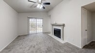 This single-floor residence offers a well-planned layout that balances comfort and functionality. The living room serves as the heart of the home, centered around a classically styled fireplace with a decorative mantel and granite surround. Vaulted ceilings and a ceiling fan lend an airy, open feel to the space, while a sliding glass door provides direct access to the outdoors and fills the room with natural light. Soft, plush carpeting runs throughout the living areas and bedroom, contributing to a warm and inviting atmosphere.

The kitchen is efficiently designed in a galley-style configuration, featuring wood-look luxury vinyl plank flooring, white cabinetry, light countertops, and stainless steel appliances including a refrigerator and range. A skylight adds a bright, open quality to the kitchen's interior. A pass-through window connects the kitchen to the living and dining area, enhancing the open-concept feel and making it easy to interact across rooms.

The bedroom is generously proportioned, featuring a ceiling fan with integrated lighting, plush carpeting, and a wide window that frames outdoor views and allows ample natural light to fill the space. The neutral color palette used throughout the residence creates a clean, cohesive aesthetic that is both modern and timeless.