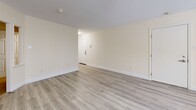 Located at 26 Beacon St in Burlington, Massachusetts, this efficiently designed single-floor unit offers a well-organized layout comprising a combined kitchen and living area, one full bathroom, and a closet. Light-toned, hardwood-style flooring runs throughout the space, lending a clean, cohesive look that enhances the sense of openness.

The living area is bright and welcoming, with large windows fitted with horizontal blinds that allow natural light to fill the room while offering privacy. Warm cream-colored walls complement the neutral flooring, creating a calm and inviting atmosphere. A structural column adds a subtle architectural detail to the open floor plan.

The kitchen is thoughtfully appointed with white cabinetry, granite-look countertops, and stainless steel appliances including a refrigerator, microwave, and range. The layout maximizes functionality within the available space, providing ample storage and counter space for everyday use.

The bathroom features a full tub-shower combination with clean white surrounds and chrome fixtures, maintaining the unit's consistent, fresh aesthetic. A dedicated closet offers convenient storage.

Throughout the unit, textured ceilings, flush-mount lighting, and well-maintained finishes contribute to a tidy and move-in-ready presentation. The overall design prioritizes practicality and comfort, making this a functional and attractive space in Burlington, MA.