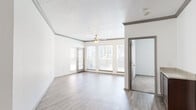 This single-floor, 2-bedroom, 2-bathroom residence offers a thoughtfully designed layout that balances comfort and functionality. The open-concept living and kitchen area serves as the heart of the home, featuring durable wood-look plank flooring, crown molding, and a ceiling fan with light fixture. A bank of large windows floods the living room with natural light and provides pleasant outdoor views of surrounding greenery. The kitchen is equipped with stainless steel appliances, including a refrigerator and microwave, dark espresso cabinetry, and a peninsula with a light stone-finish countertop that opens to the living area. The generously sized primary bedroom features plush carpet flooring, a ceiling fan, a natural light-filled window, and access to a spacious walk-in closet with wire shelving systems. The second bedroom is equally comfortable, also carpeted and well-lit. Both bathrooms are clean and functional, with one featuring a full soaking tub and tile surround. Three closets throughout the unit provide ample storage, and a dedicated laundry room with washer and dryer hookups adds everyday convenience. The unit's neutral color palette and consistent finishes create a cohesive, move-in-ready atmosphere throughout.