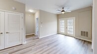 Located at 3555 Sweetwater Rd in Duluth, GA, this 2-bedroom, 1-bathroom residence offers a thoughtfully designed single-floor layout. The open-concept living, dining, and kitchen area serves as the heart of the home, featuring light hardwood-style flooring and a ceiling fan. French doors lead out to a private balcony, filling the space with natural light and outdoor views. The kitchen is well-appointed with crisp white shaker cabinets, light countertops, a double basin sink, and a full suite of stainless steel appliances including a refrigerator and dishwasher. Both bedrooms are carpeted and equipped with ceiling fans. The primary bedroom offers a comfortable footprint, while the second bedroom features a large window with views of the surrounding neighborhood. A French door connects the primary bedroom area to the main living space, adding a touch of elegance. The shared bathroom is finished with light wood-style flooring, a wide vanity with white cabinetry, a large mirror with modern lighting, and a shower-tub combination. Additional conveniences include dedicated laundry, a utility room, and two closets, rounding out this practical and inviting home.