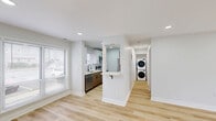 Located at 1 Pine Tree Boulevard in Old Bridge, NJ, this well-appointed single-floor residence offers a clean, modern aesthetic throughout. Light-toned hardwood flooring runs continuously across the open layout, complemented by a crisp white-and-gray color palette and recessed lighting that keeps the interior bright and welcoming.

The combined living and dining area is generously proportioned, with large windows allowing ample natural light and a sliding glass door providing direct access to a private patio. The galley-style kitchen is efficiently designed, featuring two-tone cabinetry—warm wood lower cabinets paired with white upper cabinets—quartz countertops, a subway tile backsplash, and a full suite of stainless steel appliances including a refrigerator, electric range, built-in microwave, and dishwasher.

A dedicated hallway leads to the spacious primary bedroom, which includes a closet with bifold doors and a window overlooking the exterior. A second closet provides additional storage. The bathroom is finished with full subway tile walls, a glass-enclosed shower, and a modern LED-lit vanity mirror. Completing the layout is a convenient in-unit laundry area with a stacked washer and dryer. This residence combines functional design with contemporary finishes throughout.