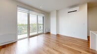 Located at 2855 Ch Bates in Montréal, this contemporary 3-bedroom, 2-bathroom unit offers a clean, modern aesthetic throughout. Light oak hardwood flooring runs seamlessly across the entire living space, complementing the crisp white walls and recessed lighting that create a bright, airy atmosphere.

The open-concept kitchen and living area serves as the heart of the unit. The kitchen is outfitted with warm wood upper cabinetry, white lower cabinets, stainless steel appliances, and a generous stone-topped island — ideal for cooking and entertaining. The living area features large sliding glass doors that open onto a private balcony, flooding the space with natural light and providing open views of the surrounding neighbourhood and greenery.

Each of the three bedrooms is finished with the same warm hardwood flooring and white walls, maintaining a cohesive and calm palette. The bedrooms feature windows with outdoor views, recessed lighting, and baseboard heating. The primary bedroom offers a comfortable footprint well-suited for a full bedroom suite.

Both bathrooms are finished in a consistent modern style, featuring large-format beige tile flooring, floating wood-toned vanities with white countertops, mirrored medicine cabinets, and glass-enclosed showers. The unit also benefits from two hallways that provide practical circulation throughout the space.