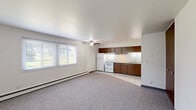 Located at 985 Wood Rd in Kenosha, Wisconsin, this one-bedroom, one-bathroom unit offers a functional and straightforward layout across a single floor. The open-concept main area seamlessly connects the kitchen and living space, creating a versatile environment suited to a variety of furniture arrangements. The kitchen is equipped with warm-toned wood cabinetry offering generous storage, a white electric range, refrigerator, and a double-basin sink set beneath under-cabinet lighting. Light ceramic tile flooring defines the kitchen zone, transitioning into neutral carpeting that covers the expansive living area. A ceiling fan provides additional air circulation throughout the main space. Baseboard heating runs along the walls, ensuring comfort during cooler Wisconsin seasons. A large window in the living area admits natural light and offers a view of the surrounding greenery. The generously sized bedroom features the same carpeted flooring and a large closet with a full-panel wood door. The bathroom includes a full tub and shower combo surrounded by classic white tile. White walls and clean lines throughout give the unit a bright, no-fuss aesthetic that is easy to personalize.