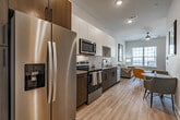 Located at 7 Vance Avenue in downtown Memphis, TN, this one-bedroom, one-bathroom unit offers a thoughtfully designed layout across a single floor. Light wood-style flooring flows throughout, complementing a bright, neutral color palette that enhances the sense of openness.

The combined kitchen and living area forms the heart of the unit. The kitchen is outfitted with stainless steel Whirlpool appliances—including a refrigerator, electric range, and over-the-range microwave—paired with two-tone cabinetry featuring dark wood lower cabinets, white upper cabinets, and granite-style countertops. The adjacent living area benefits from large windows with slatted blinds, allowing ample natural light to fill the space.

A distinctive sliding barn door provides a modern architectural touch, separating the living area from the bedroom wing. The bedroom is a serene, white-walled retreat with cozy proportions. The full bathroom features a tub/shower combination, dark hardware accents, and a vanity with matching dark wood cabinetry consistent with the kitchen design. A dedicated closet provides practical storage. The unit also includes a ceiling fan in the living area, adding both comfort and function to this well-appointed Memphis residence.