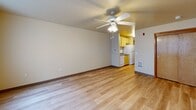 Located at 1040 NW 10th Ave in Portland's vibrant Pearl District, this studio unit offers a well-organized, single-floor layout designed to maximize every inch of space. The open main living area features light wood-tone flooring that runs throughout the unit, neutral walls, and a ceiling fan with integrated lighting that keeps the space bright and comfortable. A large window facing the urban streetscape allows natural light to fill the room, offering views of the surrounding Portland cityscape. The galley-style kitchen is efficiently arranged with light wood cabinetry, gray laminate countertops, a white electric range, microwave, dishwasher, and refrigerator — providing all essential appliances in a compact, functional corridor layout. Two closets, each with sliding wood-panel doors, offer organized storage within the main living space. The bathroom features light wood cabinetry with a built-in vanity, a tub and shower combination with grab bars, and the same light wood-tone flooring found throughout the unit. The overall ambiance is clean, functional, and move-in ready, well-suited for urban living in one of Portland's most walkable and dynamic neighborhoods.
