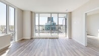 Located in Vancouver's vibrant Cambie Corridor, this well-appointed 2-bedroom, 2-bathroom unit offers a thoughtfully designed open-concept layout finished with light hardwood-style flooring throughout. The combined kitchen and living area serves as the heart of the home, anchored by a sleek, modern kitchen featuring white flat-panel cabinetry, a marble-style tile backsplash, stainless steel appliances including a full-size refrigerator, stove, built-in microwave, and dishwasher, all set against generous counter space. The living area is bathed in natural light through expansive floor-to-ceiling windows and sliding glass doors that open directly onto a private balcony, offering sweeping views of the surrounding Vancouver skyline and cityscape. Both bedrooms are comfortably sized and filled with natural light; the primary bedroom includes a dedicated closet with built-in shelving. The two bathrooms are finished in clean, contemporary style — one featuring a glass-enclosed walk-in shower with marble-look tile, and the other a full soaker tub. Additional highlights include in-unit laundry, multiple closets for ample storage, and a welcoming hallway entry. The unit's bright, neutral palette and modern finishes create a clean, cohesive aesthetic throughout.