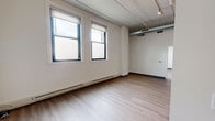 Located at 75 S 26th St in Pittsburgh's vibrant South Side neighborhood, this one-bedroom, one-bathroom unit offers a thoughtfully designed layout with a blend of industrial and modern aesthetics. The open living area features light hardwood-style flooring, exposed cylindrical ductwork along the ceiling, and large windows that invite an abundance of natural light, creating a bright and airy atmosphere throughout.

The kitchen is a standout feature, equipped with rich dark-stained cabinetry, dark granite countertops, and a full suite of stainless steel appliances including a range, built-in microwave, dishwasher, and refrigerator. A peninsula countertop provides additional prep space and adds to the open-concept flow between the kitchen and living area.

The bedroom is a comfortable, well-proportioned room with light hardwood flooring, dual windows, and baseboard heating. It is complemented by a dedicated walk-in closet featuring wire shelving and carpeted flooring, offering generous storage space.

The full bathroom includes a combined shower and soaking tub with clean white surrounds and chrome fixtures. Track lighting and baseboard heating are found throughout the unit, completing this functional and stylish space.