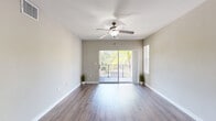 Located in Orlando's Falcon Parc community, this 2-bedroom, 2-bathroom residence offers a thoughtfully designed single-floor layout with a cohesive blend of style and functionality. The entryway, equipped with a smart thermostat and louvered closet doors, leads into an open-concept living and kitchen area finished with rich wood-style plank flooring throughout. The kitchen features dark espresso cabinetry, granite-style countertops, stainless steel appliances, and a breakfast bar peninsula that opens seamlessly to the living space. Track lighting adds a modern touch overhead. The living room is bright and airy, highlighted by a ceiling fan, sliding glass doors that open to a private balcony with outdoor views of lush greenery, and abundant natural light. The primary bedroom is generously sized with plush carpeting, a ceiling fan, and natural light from large windows. The primary bathroom boasts an extended dark-wood vanity with granite countertops and tile flooring. The second bedroom also features carpet and a ceiling fan with a sun-filled window. Additional conveniences include an in-unit laundry area with a full-size washer and dryer and overhead shelving, completing this well-rounded home.