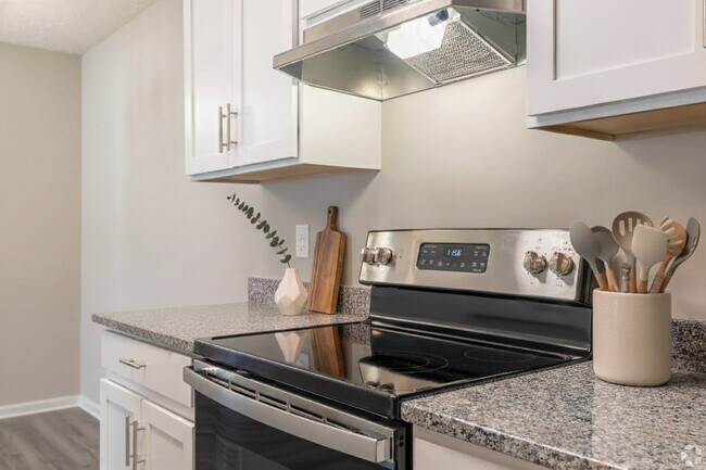 Cocina moderna con encimeras de granito y electrodomésticos de acero inoxidable. - Hidden Lake