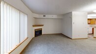 Located at 1170 Northwood Dr in Eagan, Minnesota, this two-floor home offers a thoughtfully laid-out interior with consistent finishes throughout. The living room serves as a central gathering space, highlighted by a wood-trimmed gas fireplace set against neutral walls and plush carpeting. A large window allows natural light to fill the room, creating a warm and inviting atmosphere.

The kitchen is well-appointed with warm oak cabinetry, light countertops, and a peninsula that provides additional workspace and casual dining potential. A window above the sink brings in natural light, and tile flooring adds durability to this high-use area. White appliances, including a refrigerator, electric range, microwave, and dishwasher, are all included.

The bedrooms are carpeted and feature neutral wall tones, with windows fitted with vertical blinds for light control. Closet storage is provided via bi-fold doors. The bathrooms are clean and functional — one includes a vanity with a large mirror and warm oak cabinetry, while another features tile flooring, a walk-in shower, and a wall-mounted cabinet for additional storage.

Throughout the home, wood-toned six-panel doors, warm baseboards, and textured ceilings maintain a cohesive and classic aesthetic, making this Eagan residence a practical and comfortable space.