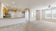 Located in La Quinta, California, this well-designed one-bedroom, one-bathroom residence offers a comfortable and functional single-level layout. The open-concept living and dining area is spacious and filled with natural light from large windows dressed with blinds, and features plush wall-to-wall carpeting and recessed lighting throughout. A sliding glass door leads to an outdoor access point, enhancing the sense of openness. The kitchen is positioned adjacent to the living area and features warm wood-toned cabinetry, a peninsula breakfast bar with a granite-style countertop, stainless steel appliances including a refrigerator and microwave, and easy-care tile flooring. The bedroom is generously sized, with carpet flooring, a ceiling fan, and a bright window overlooking the surroundings. It is complemented by a large walk-in closet outfitted with built-in shelving and hanging rods, offering ample storage. The full bathroom includes a soaking tub and shower combination with clean white surround, a vanity with stone-style countertop, and wood-look flooring. A hallway connects the main living spaces, completing this practical and comfortable floor plan suited for everyday living in the desert resort community of La Quinta.