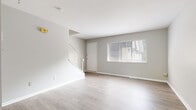 Located at 1723 Dominion Dr in Akron, Ohio, this three-floor home offers a well-organized layout spread across distinct living levels. The main floor presents an open living area finished with light-toned luxury vinyl plank flooring and neutral gray walls, creating a bright and clean aesthetic. A large front-facing window allows natural light to fill the space, while a decorative white wrought-iron staircase railing adds a classic architectural detail.

The kitchen is equipped with dark, raised-panel cabinetry that contrasts with light stone-look countertops and matching light plank flooring. A sliding glass door provides direct access to an outdoor deck, enhancing the connection between indoor and outdoor living. A dishwasher and under-cabinet range hood are also present.

The upper floor hosts multiple bedrooms featuring warm-toned hardwood flooring, ceiling fans, and windows that bring in natural light. The carpeted staircase leading to this level is lined with white trim and a simple metal handrail.

The lower level offers a utility and storage area with painted concrete block walls, a sealed floor, and functional utility access, providing practical additional space for the home.