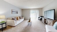 Located at 100 Star Blvd in Nashville, TN, this single-floor, 2-bedroom, 2-bathroom residence offers a practical and comfortable layout. The living room serves as the heart of the home, featuring plush carpeting, neutral gray walls, a textured ceiling, and a large sliding glass door that fills the space with natural light and provides outdoor views. Adjacent to the living area, the dining room offers a cozy setting beneath a classic chandelier, with carpeted flooring and clean, neutral walls. The kitchen is equipped with warm wood cabinetry, light countertops, a double basin sink, and black appliances including a refrigerator and dishwasher, alongside light hardwood-style flooring. The primary bedroom is a well-proportioned retreat with carpeted flooring, soft natural light from dual windows with sheer curtains, and a calm, neutral palette. The second bedroom offers flexibility as a guest room or home office, with a window providing natural light and ample floor space. Both bathrooms feature wood-toned vanities, white countertops, large mirrors, tub-shower combinations, and wood-style flooring. A hallway and closet round out the functional layout of this well-maintained Nashville residence.