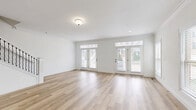 This well-appointed three-floor home offers generous living space spread across a thoughtfully designed layout, featuring 2 bedrooms and 4 bathrooms. Light hardwood flooring flows consistently throughout the main and upper levels, complementing a bright, neutral color palette of crisp whites and warm tones that creates an airy, welcoming atmosphere.

The main level hosts an open-concept kitchen and living area, anchored by light maple cabinetry with decorative hardware and stone countertops. A dedicated dining room sits adjacent, connected via a graceful arched doorway that adds architectural character. French doors and oversized windows flood the living spaces with natural light and provide access to outdoor areas.

Upper floors house the bedrooms, each featuring ceiling fans, natural light from well-positioned windows, and access to closet storage. Multiple closets are distributed throughout the home, including walk-in configurations with wire shelving systems. A dedicated laundry room and pantry add practical convenience.

The lower level contains an unfinished basement, complete with a sump pump and visible mechanical systems, offering significant potential for future customization. A utility room and additional staircases round out the multi-floor layout. Clean lines, crown molding details, and recessed lighting throughout contribute to the home's polished, modern aesthetic.