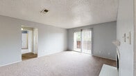 Located at Park Springs Circle in Arlington, TX, this two-bedroom, one-bathroom single-floor residence offers a practical and comfortable layout across a well-utilized footprint. The open-concept living, dining, and kitchen area forms the heart of the home, with the carpeted living room featuring a textured ceiling, a corner fireplace, and sliding glass doors that lead to a private patio, allowing natural light to fill the space. The galley-style kitchen is efficiently designed with white cabinetry, granite-look countertops, a subway tile backsplash, black appliances including a range, dishwasher, and refrigerator, complemented by wood-look flooring that flows throughout the kitchen and hallway. Both bedrooms are carpeted and feature soft gray walls, textured ceilings, and ceiling fans with light fixtures. The primary bedroom is generously sized and includes closet access, while the second bedroom offers a window with natural light. Two closets provide ample storage throughout the unit. The full bathroom includes a vanity with a granite-look countertop, white cabinetry, a tub/shower combination, and wood-look flooring, maintaining a clean and cohesive aesthetic. A hallway connects the main living areas to the bedrooms, completing this functional and well-appointed single-floor home.