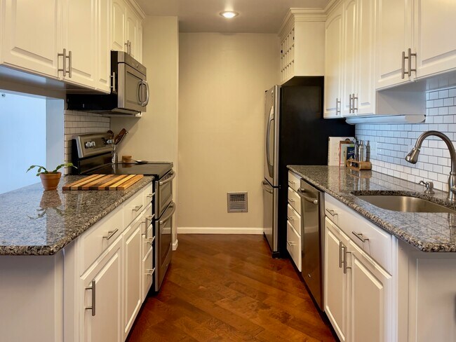 Las encimeras de granito y los azulejos blancos del metro hacen que esta cocina sea única. - 2262 Benson Ave