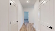 Located at 8550 N Main St in Kansas City, MO, this well-appointed 2-bedroom, 2-bathroom unit offers a thoughtfully designed single-level layout with a clean, contemporary aesthetic throughout. The open-concept living and kitchen area serves as the heart of the home, featuring light hardwood-style flooring, recessed lighting, and an abundance of natural light from multiple windows. The kitchen is equipped with stainless steel appliances, including a range, microwave, and dishwasher, complemented by dark espresso cabinetry, white quartz countertops, and a central island with a sink — ideal for both cooking and casual dining. A ceiling fan in the living area adds comfort and airflow. Both bedrooms are carpeted and feature ceiling fans, with windows that offer outdoor views. The spacious primary bedroom includes its own dedicated closet with extensive wire shelving for organized storage. The primary bathroom presents a modern vanity with dark wood cabinetry, white countertops, a walk-in shower with white tile surround, and light tile flooring. The secondary bathroom features a tub/shower combo with white subway tile and matching black hardware accents. A hallway connects all areas cohesively, and two closets provide ample storage throughout the unit.