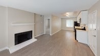 This single-story residence at 624-656 S Glendora Ave in West Covina, California offers a well-organized layout with a clean, updated aesthetic throughout. The open living area serves as the heart of the unit, highlighted by a tile-surround fireplace with a white mantel and durable wood-look flooring that extends through the main living spaces. Natural light filters in through blinds-covered windows, contributing to a bright and welcoming atmosphere.

The kitchen has been thoughtfully updated with crisp white shaker-style cabinetry, light quartz countertops, and a classic white subway tile backsplash. A full suite of stainless steel appliances—including a gas range, over-the-range microwave, dishwasher, and refrigerator—adds a modern, functional touch. An adjacent dining area benefits from a window view and continues the wood-look flooring.

The bedroom is generously sized, featuring plush wall-to-wall carpeting and dual windows that invite ample natural light from multiple directions. The bathroom is finished with wood-look flooring, a soaking tub with shower, a white vanity with quartz countertop, and a window for ventilation. Neutral warm-beige walls and textured ceilings are consistent throughout, creating a cohesive and move-in ready living environment.