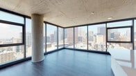Located in Chicago, IL, this high-rise unit showcases a distinctly modern industrial aesthetic defined by exposed concrete ceilings throughout, dark hardwood-style flooring, and an open, airy layout. The living area is a standout feature, anchored by a prominent concrete structural column and wrapped in floor-to-ceiling corner windows that frame sweeping, panoramic views of the Chicago skyline. The abundance of natural light and elevated vantage point create a compelling urban atmosphere.

The kitchen is thoughtfully designed with white cabinetry, a large waterfall-edge island with an integrated sink, stainless steel appliances including a gas range, microwave, and refrigerator, and track lighting mounted to the exposed concrete ceiling above.

The bedrooms are well-proportioned, each featuring dark hardwood-style flooring, clean white walls, exposed concrete ceilings, and large windows offering additional skyline views, filling each room with natural light.

The bathrooms are finished with a clean, contemporary aesthetic, featuring white vanities with undermount sinks, large mirrors, wood-toned flooring, and glass-enclosed walk-in showers clad in large-format marble-style tile with polished chrome fixtures. The overall ambiance of the space is sleek, modern, and urban.