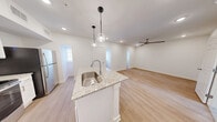 Located at 2625 Ridgewood Rd in Jackson, Mississippi, this one-bedroom, one-bathroom unit offers a thoughtfully designed single-floor layout. The open-concept living and kitchen area serves as the heart of the space, showcasing light hardwood-style flooring, recessed lighting, and a central granite-topped island with an undermount sink and pendant lighting overhead. The kitchen is outfitted with crisp white cabinetry, a subway tile backsplash, granite countertops, and a full suite of stainless steel appliances including a refrigerator, electric range, and built-in microwave. The generously sized bedroom features plush wall-to-wall carpeting and a ceiling fan with integrated lighting, creating a comfortable retreat. A dedicated walk-in closet with wire shelving provides ample storage. The full bathroom includes a tiled soaking tub and shower combination with clean, bright finishes. A standout feature of this unit is access to a large outdoor terrace with tile flooring and metal railing, offering open views of the surrounding tree-lined neighborhood and skyline — an ideal space for outdoor relaxation. The overall aesthetic is clean, modern, and move-in ready.
