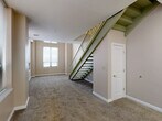 This two-story, 2-bedroom, 3-bathroom residence offers a well-organized layout spread across two generously sized floors. The main level features a welcoming entrance that opens into a combined dining, kitchen, and living area, providing an open and functional living space. A pantry and dedicated laundry room add everyday convenience, while a half bathroom is accessible on this floor. The striking metal staircase with open risers and a sleek green-painted frame serves as a functional focal point, connecting both levels with a modern industrial aesthetic. Soft carpet flooring flows throughout the living and bedroom areas, while the bathrooms and transitional spaces feature wood-look vinyl plank flooring. Large windows on both floors invite abundant natural light, giving the interiors a bright and airy feel. The upper floor houses two bedrooms, including a spacious primary bedroom with multiple windows, along with two full bathrooms. Each bathroom is finished with clean white vanities and light-toned flooring. Additional storage is provided through four closets distributed throughout the home. A utility room and hallway round out the thoughtful floor plan, ensuring both comfort and practicality throughout this well-appointed two-level residence.