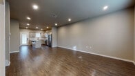 Located at 560 West Bryant Street in Springfield, Missouri, this two-story home offers a well-designed layout with modern finishes throughout. The main floor features an open-concept living and kitchen area unified by rich, dark hardwood-style flooring and recessed lighting. The kitchen is equipped with stainless steel appliances, a center island, gray shaker-style cabinetry, a subway tile backsplash, and a window that brings in natural light. A convenient half bath on the main level includes a pedestal sink and hardwood-style flooring with classic oil-rubbed bronze hardware accents. Upstairs, the bedrooms are carpeted for comfort, with one standout room boasting vaulted ceilings and a ceiling fan, adding a sense of volume and airiness. Each bedroom benefits from natural light through window blinds. The upper level also includes a full bathroom featuring a glass-enclosed walk-in shower with black-framed doors and hardwood-style flooring. Storage is well addressed throughout, with multiple walk-in closets fitted with wire shelving systems — one carpeted and one with hardwood-style flooring. A staircase with a white baluster railing connects the two floors, completing this thoughtfully laid-out home.