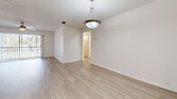 Located at 1918 Plantation Key Cir in Brandon, FL, this single-story home offers a bright, clean interior finished throughout with light wood-look flooring and a crisp, neutral color palette. The open layout connects living and adjacent areas seamlessly, with ceiling fans, textured ceilings, and chair-rail-style wall molding adding subtle architectural detail to the main living spaces. Large sliding glass doors in the living area invite natural light and provide views of the surrounding greenery, while vertical blinds offer privacy and light control.

The kitchen is well-appointed, featuring light wood cabinetry, white countertops, a peninsula for additional prep and serving space, stainless steel appliances including a refrigerator, range, and dishwasher, and overhead fluorescent lighting for ample task illumination. A dedicated utility area conveniently houses a full-size washer and dryer alongside additional cabinetry and a utility sink.

The bedrooms are generously proportioned, each featuring the same light flooring, wall molding details, and windows fitted with horizontal blinds that allow for natural light. The bathroom includes a single-sink vanity with light wood cabinetry and white countertops, a toilet, and a tub-shower combination with tile surround. Throughout the home, the consistent finishes and open flow create a cohesive and functional living environment.