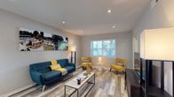 This single-floor residence at 500 Northside Cir in Atlanta, Georgia offers a thoughtfully updated interior finished with light gray wood-look flooring that flows consistently throughout the space. The living room serves as the heart of the unit, featuring recessed lighting, a large window with blinds that invites natural light, and enough room to comfortably accommodate a full seating arrangement. A panoramic wall art display adds a distinctive visual focal point to the living area.

The kitchen is well-equipped with modern flat-front cabinetry in a warm wood-grain finish, stainless steel appliances including a French door refrigerator, electric range, microwave, and dishwasher. Light countertops and under-cabinet lighting enhance both functionality and aesthetics, while a peninsula provides additional prep and seating space.

The bedroom is a comfortable retreat with a ceiling fan, natural light from a window, and a dedicated closet with built-in shelving. Additional storage is conveniently accessible nearby.

The bathroom features marble-look tile flooring, subway tile surround around the tub-shower combination, a wood-grain vanity with a white countertop, and a framed mirror. A connecting hallway ties all areas together cleanly, reinforcing the unit's cohesive, contemporary design.