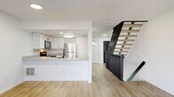 Located at 6680 Oak Bend Commons Way in Columbus, OH, this multi-level home spans three floors and offers a well-organized layout with 2 bedrooms, 3 bathrooms, and dedicated spaces across each level. The main floor features a bright, open-concept kitchen equipped with white shaker-style cabinetry, black hardware accents, stainless steel appliances including a refrigerator, range, microwave, and dishwasher, and light wood-look flooring that flows throughout. A bold black metal staircase serves as a striking architectural focal point connecting the floors. The living area is bathed in natural light through large sliding glass doors fitted with vertical blinds, offering outdoor views. The upper level houses two carpeted bedrooms, each featuring natural light from windows, with the primary bedroom offering a comfortable, well-proportioned retreat. The three bathrooms are finished in a clean, modern style with white vanities, black hardware, and light hardwood-style flooring — one featuring a full tub-shower combination. The unfinished basement provides ample utility space, housing a full-size washer and dryer, with exposed joists and concrete block walls offering strong storage or workshop potential. Textured ceilings are consistent throughout the home.
