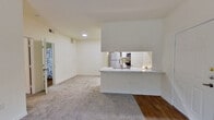 This thoughtfully designed 1-bedroom, 1-bathroom unit offers an efficient and comfortable single-floor layout. The open-concept kitchen and living area serves as the heart of the home, where wood-style flooring in the kitchen transitions seamlessly into plush carpeting in the living space. The kitchen is equipped with stainless steel appliances — including a refrigerator, electric range, and microwave — complemented by white shaker-style cabinetry and a peninsula with marble-look countertops and a built-in sink, ideal for casual dining or food prep. Natural light flows into the living area through large windows fitted with horizontal blinds.

The bedroom is a well-sized retreat featuring soft carpet flooring, a large window with outdoor views, and a charming built-in shelving nook with a marble-look countertop surface — perfect for a workspace or vanity. A spacious walk-in closet with wrap-around wire shelving and hanging rods provides generous storage. The full bathroom includes a marble-look vanity, a tub-shower combination, and wood-style flooring. A dedicated laundry area with a full-size washer and dryer rounds out this unit's practical and comfortable living experience.