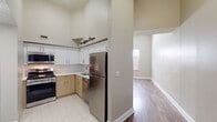 Located at 152 Temple Street in the heart of New Haven, CT, this single-floor unit offers a well-designed layout with notable architectural details throughout. Soaring ceilings create an expansive, airy atmosphere across the living areas, which are finished with warm hardwood-style flooring that extends seamlessly through the main rooms.

The kitchen is a standout feature, equipped with a full suite of stainless steel appliances including a gas range, over-the-range microwave, dishwasher, and full-size refrigerator. Crisp white upper cabinetry is complemented by natural wood-toned lower cabinets and clean white countertops, all set over light tile flooring. The layout is efficient and functional, opening directly to the adjacent living area.

The bedrooms are generously proportioned, benefiting from the high ceilings and natural light admitted through large windows. One bedroom includes a walk-in closet with shelving, while another features a built-in closet with overhead storage. Neutral wall tones throughout the unit contribute to a calm, cohesive aesthetic.

The bathroom is cleanly finished with white tile flooring, a wood-vanity with an undermount sink, a large mirror with overhead lighting, and a tub-shower combination. The overall ambiance of the space is modern, clean, and bright, making it a practical and comfortable urban residence in one of New Haven's central corridors.