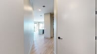 Located at 6901 E Main St in the heart of Scottsdale, Arizona, this modern 3-bedroom, 2-bathroom residence offers a thoughtfully designed single-level floor plan. Light wood-tone flooring flows throughout the main living areas, complementing a clean, neutral color palette and contemporary finishes.

The open-concept kitchen and living area serves as the centerpiece of the home. The kitchen features stainless steel appliances including a gas range, microwave, and full-size refrigerator, paired with light wood cabinetry, a blue tile backsplash, and a generous white-quartz island with pendant lighting overhead. Large windows flood the space with natural light, while a ceiling fan and expansive sliding glass doors open to a private balcony offering open views of the Scottsdale skyline and palm-lined streetscape.

The spacious primary bedroom includes direct balcony access through floor-to-ceiling sliding glass doors, maximizing natural light and outdoor connectivity. Its en-suite bathroom is finished with large-format tile, a frameless glass walk-in shower, wood-tone vanity cabinetry, and a dedicated closet. The additional bedrooms are carpeted and well-lit with natural light from window blinds. A built-in wine or beverage cooler adds an elevated touch to the entertaining space.